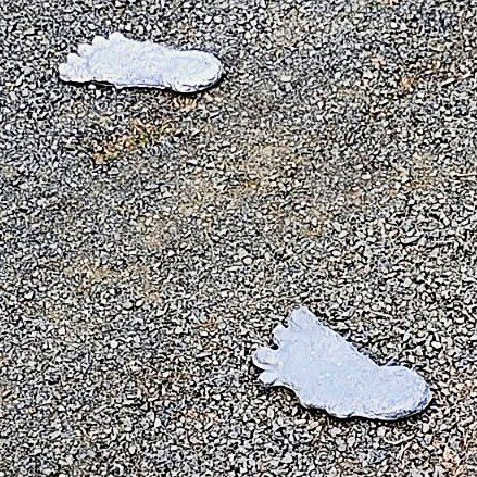 Footprint sculptures on gravel surface